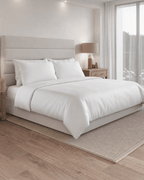 Soft Grey bedding set on a bed in a bedroom with a lamp and mirror.