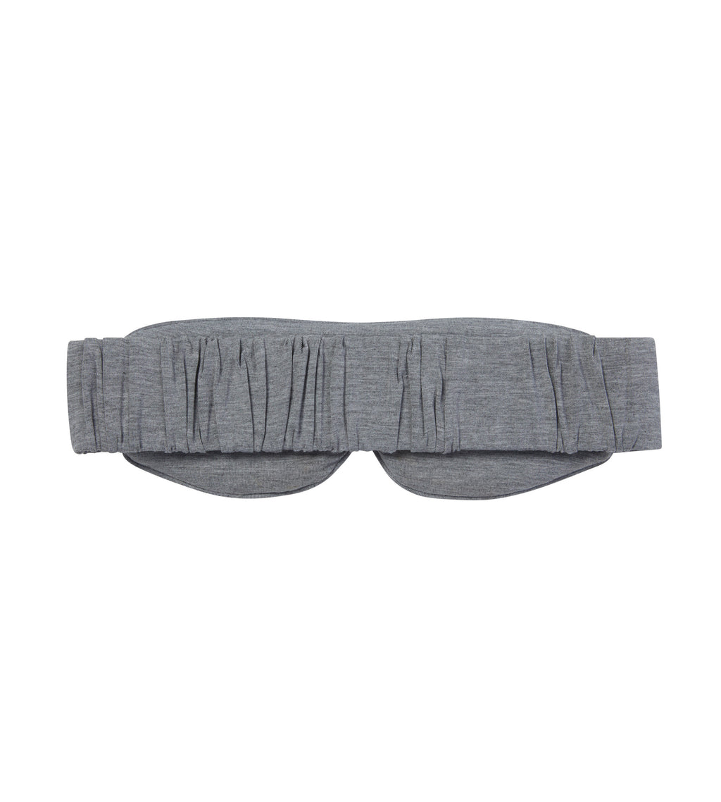 The back of a grey sleep mask on a white background