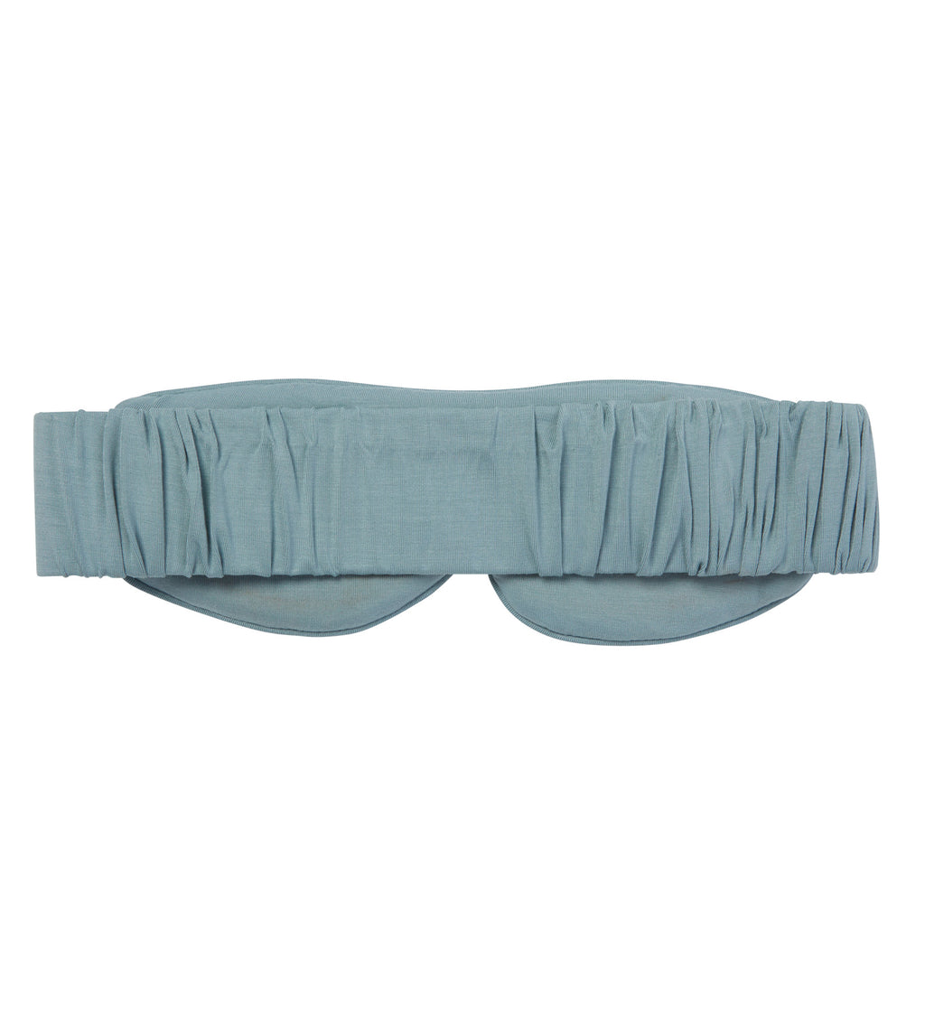 The back of a light blue eye mask with a gathered, pleated fabric design, shown flat against a solid white background.