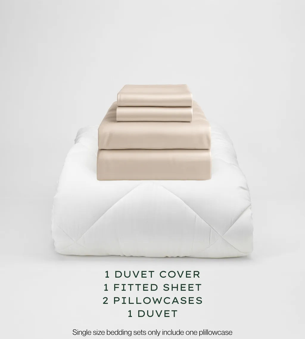 Oatmeal bedding set with duvet, duvet cover, fitted sheet, and pillowcases on a light gray background.