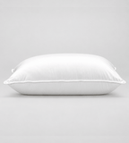 A white rectangular pillow with a smooth satin-like finish, photographed against a neutral light grey background.