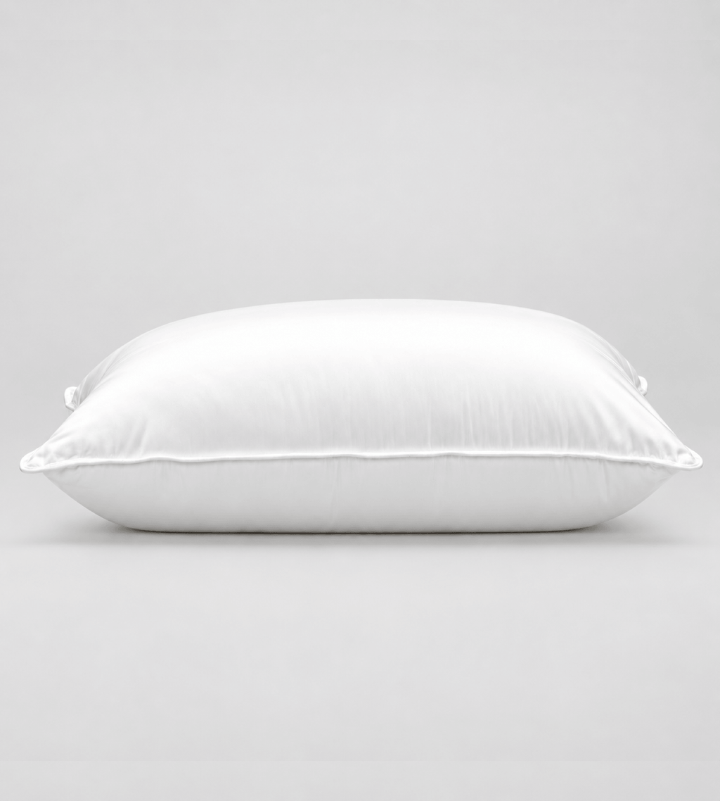A white rectangular pillow with a smooth satin-like finish, photographed against a neutral light grey background.