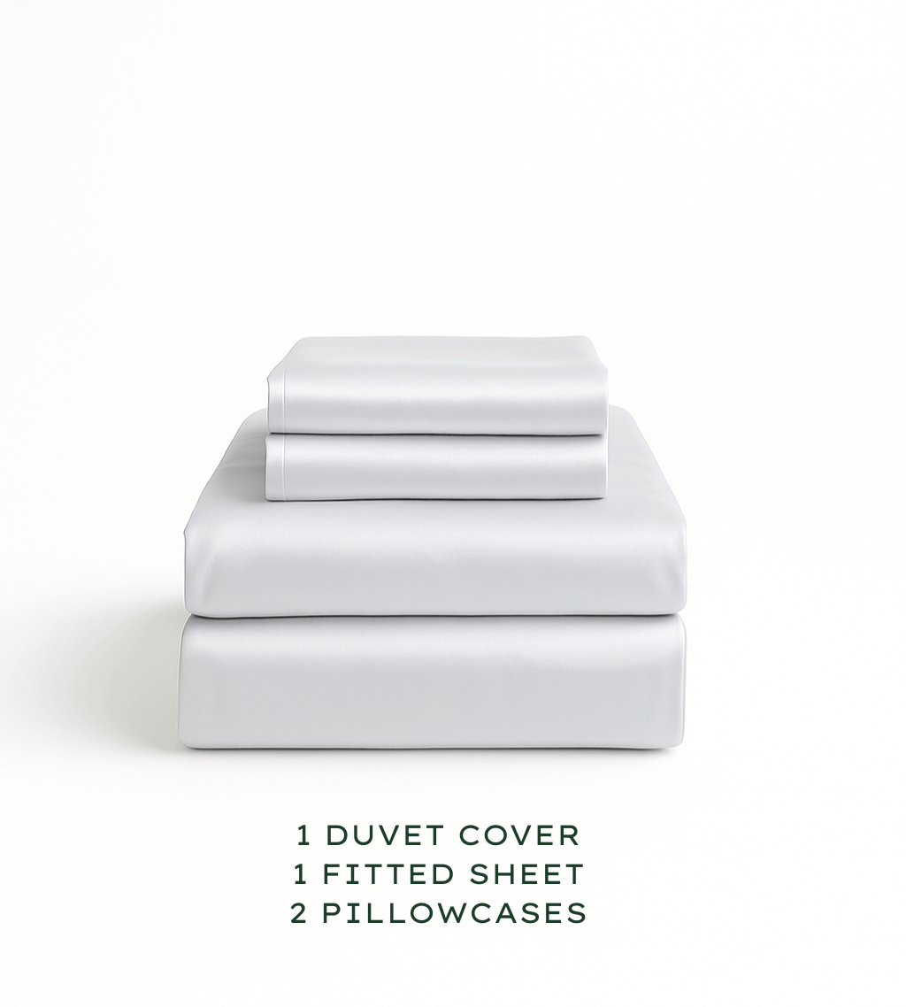 Set of white bedding including a duvet cover, fitted sheet, and pillowcases on a white background.