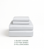 Set of white bedding including a duvet cover, fitted sheet, and pillowcases on a white background.